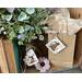 Handmade birch bark tags. One decorates a vase and the other is tied to a kraft gift bag with a piece of natural twine.